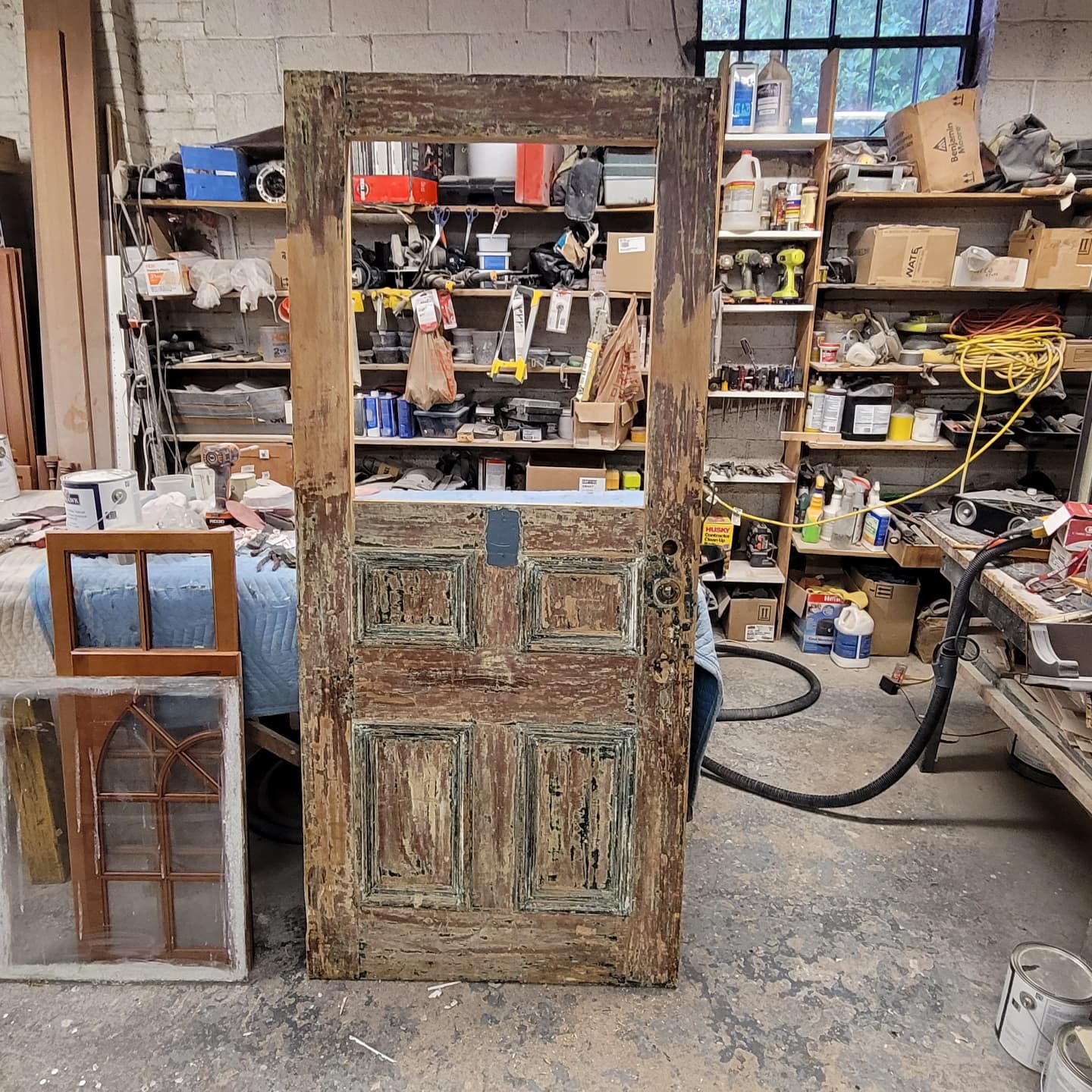 Antique paneled door before restoration, with worn, peeling paint