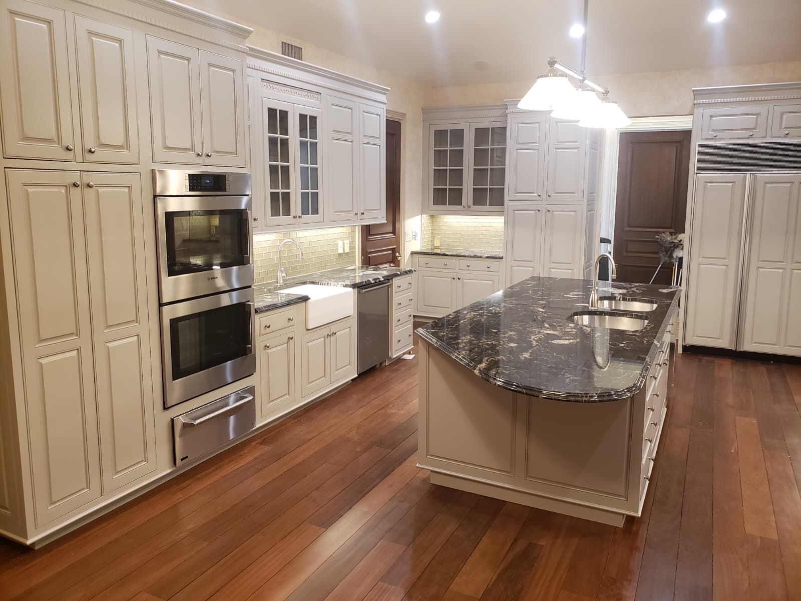 Kitchen wall with double ovens and refinished cabinets