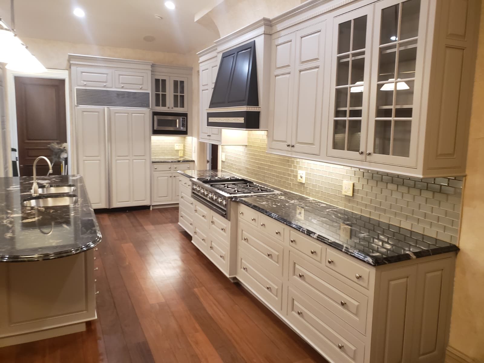 Kitchen range with black hood and refinished cabinetry