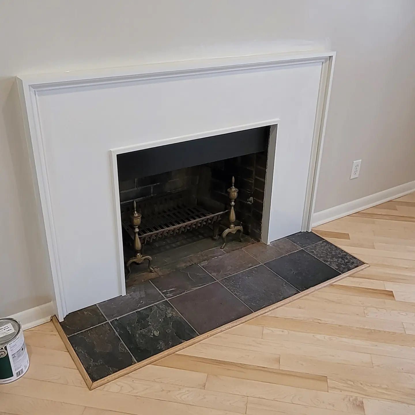 Finished white mantel with slate hearth, angled view