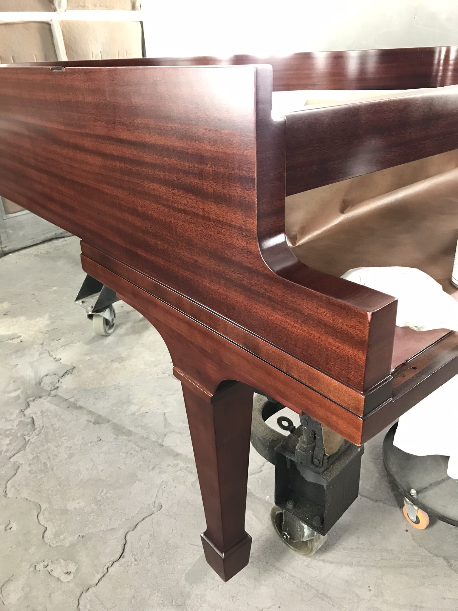 Restored mahogany grand piano with deep polished finish
